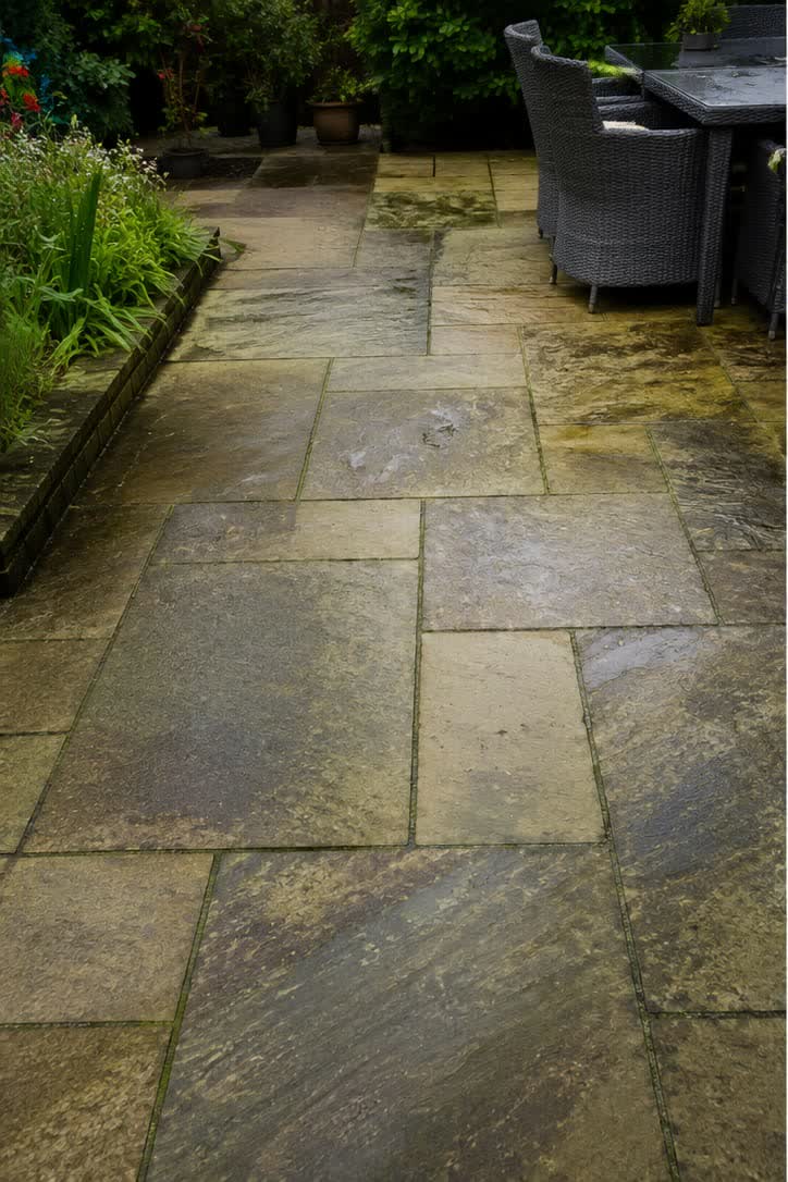 Indian sandstone patio darkened with algae and organic staining before restoration